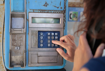mujer llamando en cabina telefónica