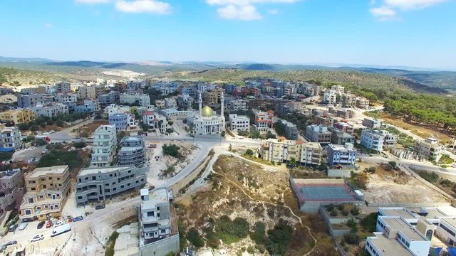 Arab Muslim village with a golden mosque on top of the mountain - Aerial footage