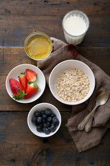  raw oat flakes in bowl and berries