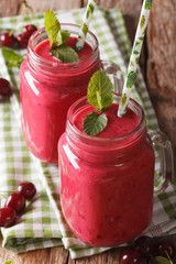 Cherry cocktail with mint in glass jar closeup. vertical 

