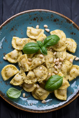 Ravioli served with basil pesto sauce, fresh basil and pine nuts