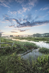 Beautiful vibrant Summer sunrise over English countryside landsc