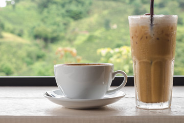 Cup of coffee and Iced coffee on wooden table with blur background