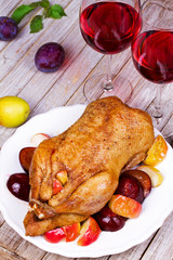 Roasted apple and plum stuffed duck. Glasses of red wine. View from above, top studio shot