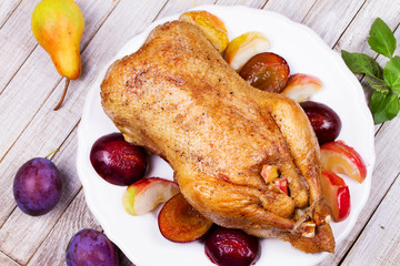 Roasted apple and plum stuffed duck. View from above, top studio shot