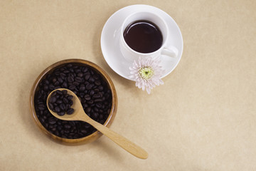 Black coffee in white cup and coffee beans. Top view.