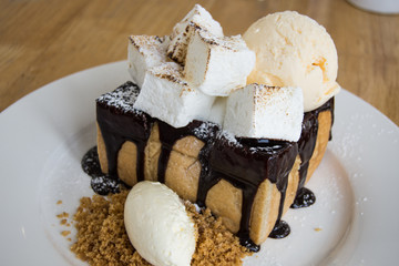 Chocolate Honey Toast with Ice Cream and Marshmallow on wooden table