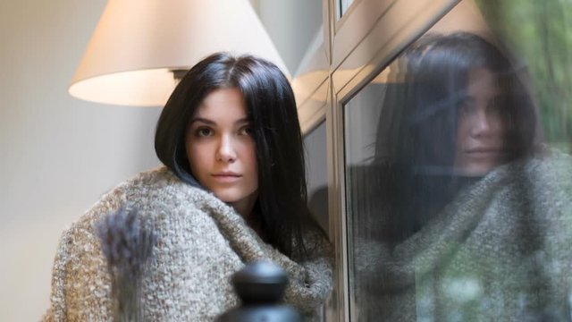 beautiful girl sitting on a background of the rainy window. HD cinemagraph - motion photo seamless loop