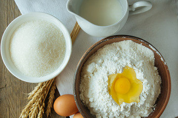 Flour, sugar, milk and eggs top view