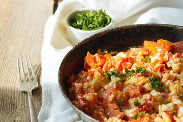 Scramble eggs with tomatoes in pan copy space
