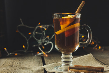 Mulled wine in glass and cinnamon pipes