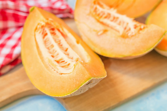 Slices of cantaloupe melon on rustic table