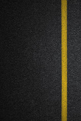Level asphalted road with a dividing yellow stripes. The texture of the tarmac, top view.