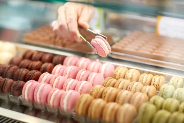 Muurstickers Taking out macaron from glass case © luckybusiness