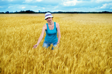 Naklejka na ściany i meble girl stands on a wheat field