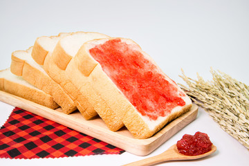 sliced bread with a strawberry jam on wood plate