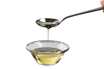 Pouring virgin olive oil in a bowl close up.