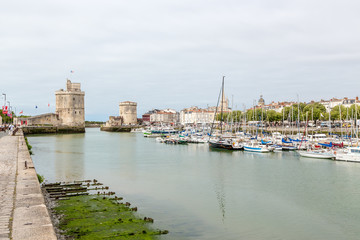 Fototapeta na wymiar La Rochelle, France. Old Port and the medieval watchtowers. Left -. St. Nicholas Tower, 1345-76 years. Right - Chain Tower, 1382-90 years. UNESCO list