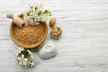Spa treatment with blooming branch on white wooden table
