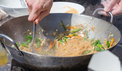 Streen food. Noodles with vegetables fried in a frying pan.