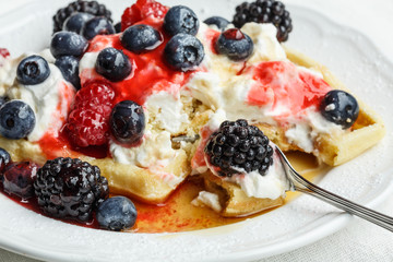 Belgian waffles with whipped cream,berry fruits, maple and raspberry syrup