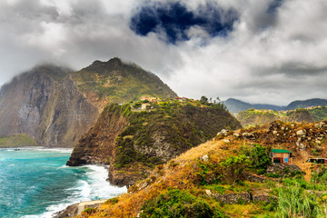 Fototapeta na wymiar Rocky beach and cliffs on the northern coast of Guindaste, Faial, Madeira, Portugal.