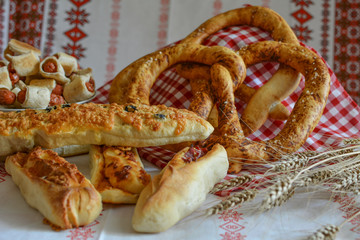Savory pastries, pretzel, loaf of bread, rolls, homemade mini hot dogs and ears of barley