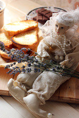 Fototapeta na wymiar Doll with sprigs of lavender