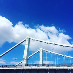 Большой белый мост на фоне голубого неба и облаков.