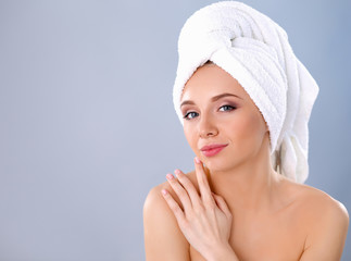 Beautiful woman with a towel on her head on a gray background