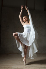Beautiful ballerina dancing in white dress