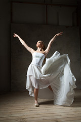 Beautiful ballet dancer in white costume with waving skirt dancing