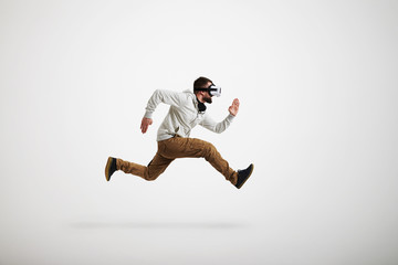 Man in virtual reality headset photographed in jump on white bac