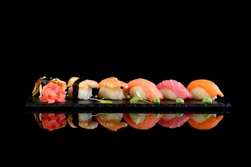 Fotobehang Assorted sushi on a black background with reflection © Vitaliy