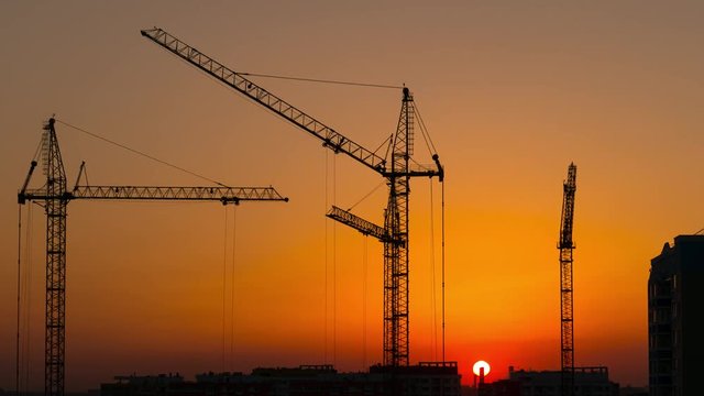 timelapse sunset and silhouette crane working in construction site, 4k UHD 2160p