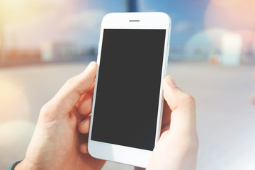 Technology and communication concept. Young businessman reading news on the Internet magazine, texting a message vis e-mail, using smart phone with blank copy space screen for your promotional content