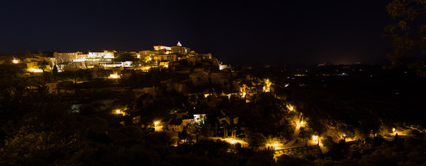 Fototapeta premium Pueblo de Gordes, Provenza, Francia. Pueblo iluminado en lo alto de una colina durante la noche