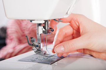 Woman threading on sewing machine