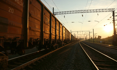 Plakat Freight train moving on the tracks at sunset