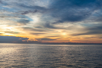 Photo of tropical sky at sunset.Seascape. Sun in the clouds over the sea. Horizontal picture.