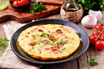 Scrambled eggs with ham, tomato and parsley