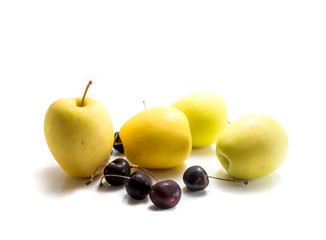 Isolated yellow apples and black cherries