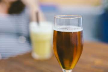 Blond beer on a glass close up on a wooden table