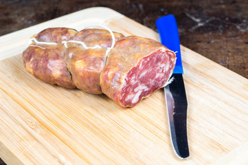 Tagliere di salumi e formaggi in primo piano su tavolo antico, tagliere di saleme in primo piano