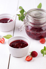 Strawberry jam in a jar on wooden background