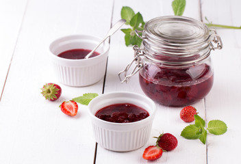 Strawberry jam in a jar on wooden background