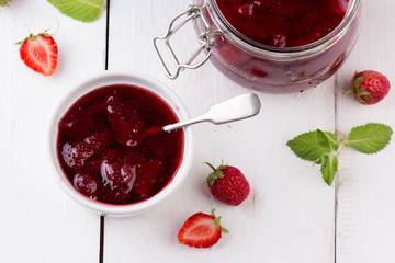Strawberry jam in a jar on wooden background