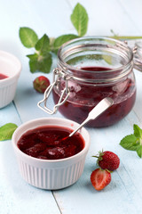 Strawberry jam in a jar on wooden background