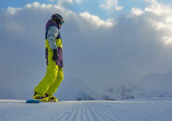 snowboarder standing on the board in the mountains