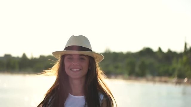 Girl in hat smiling on the background of the sea.